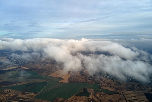 Aerial view from high altitude of earth covered with puffy rainy clouds forming before rainstorm.