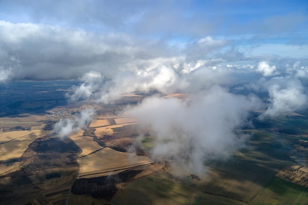 Вид с воздуха с большой высоты на землю, покрытую пухлыми дождливыми облаками, формирующимися перед ливнем
