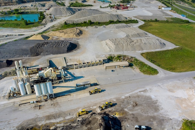 Aerial view from above of open cast mining quarry with machinery at work