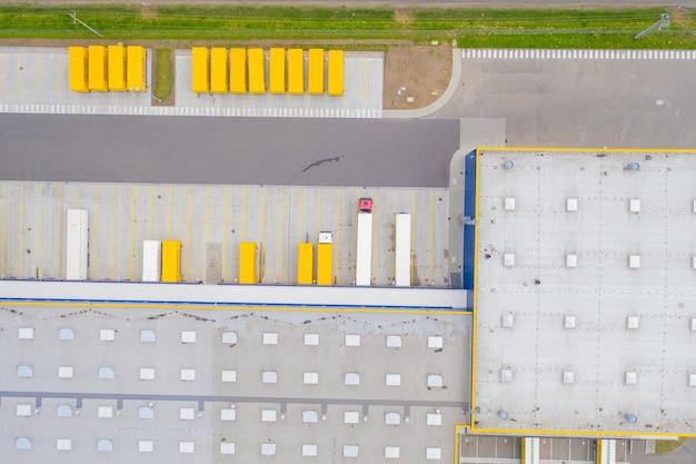 Aerial view of goods warehouse logistics delivery center in industrial trucks loading at logistic