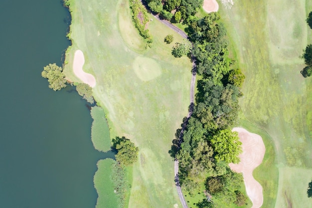 Aerial view of the green golf course in Thailand Beautiful green grass and trees on a golf field with fairway and putting green in summer season