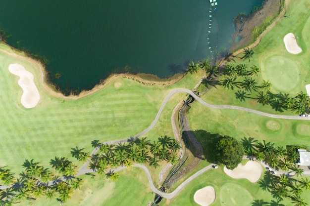 Aerial view of the green golf course in Thailand Beautiful green grass and trees on a golf field with fairway and putting green in summer season