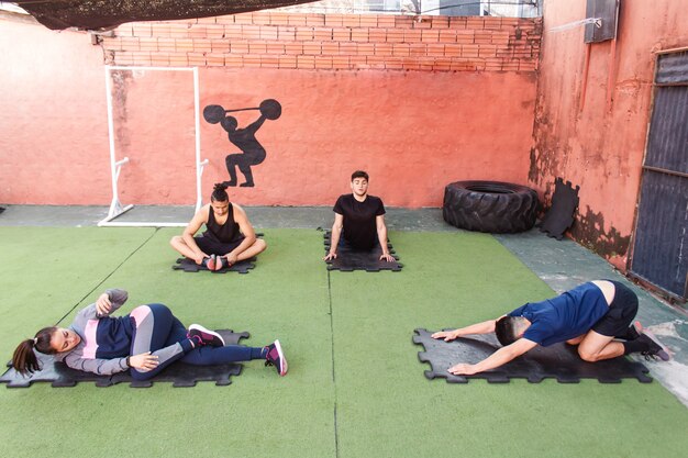 Aerial view of a group of friends stretching before training in the gym courtyard.