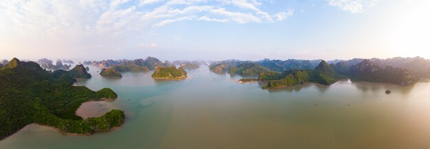 Aerial view of Ha Long Bay Cat Ba island, unique limestone rock islands and karst formation peaks in the sea, famous tourism destination in Vietnam. Scenic blue sky.