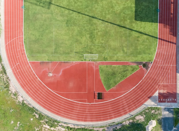 Photo aerial view on half of soccer field, football field with numbers on red running track.