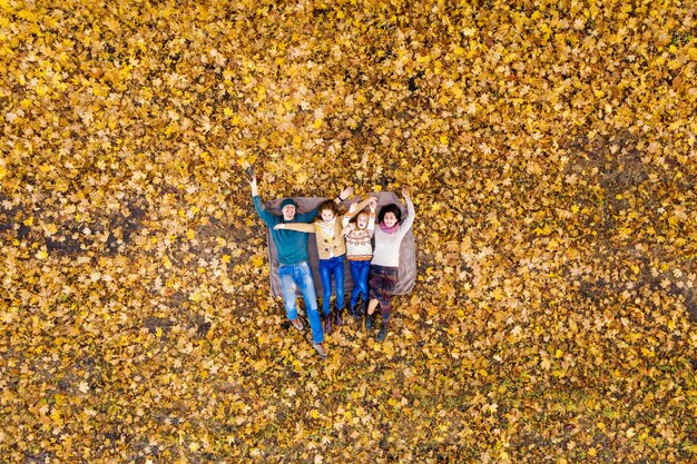 Aerial view of happy family lying in autumn park