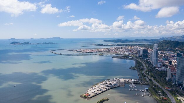 パナマシティの海岸線を横断する港と近代的な高層ビルを空中から眺める