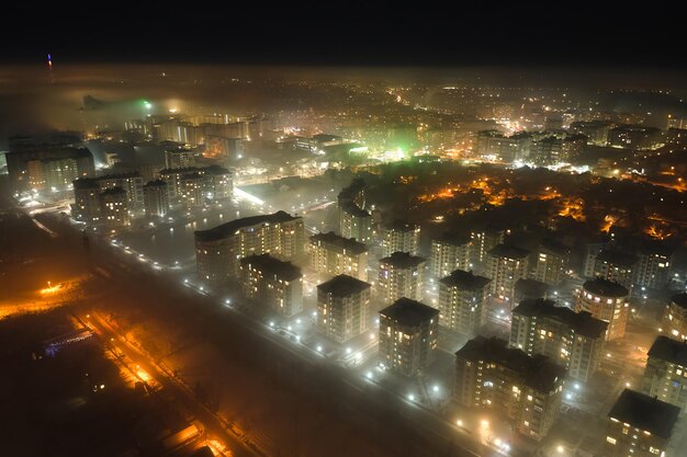 고층 아파트 건물과 밤에 도시 주거 지역의 밝은 조명 거리의 공중 전망. 어두운 도시 풍경
