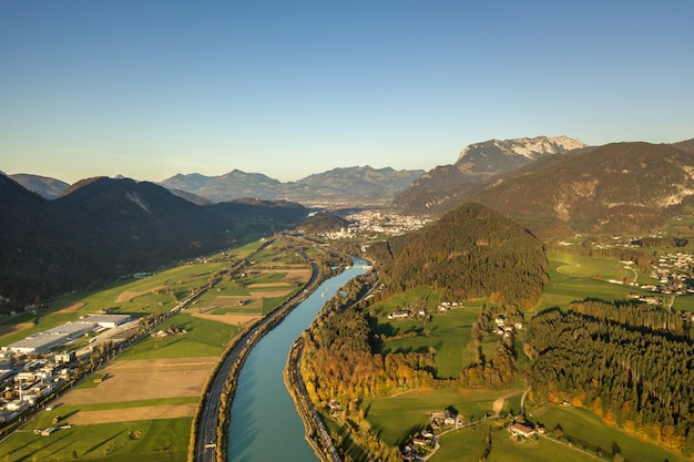 Aerial view of highway interstate road with fast moving traffic near big river in Alps mountains