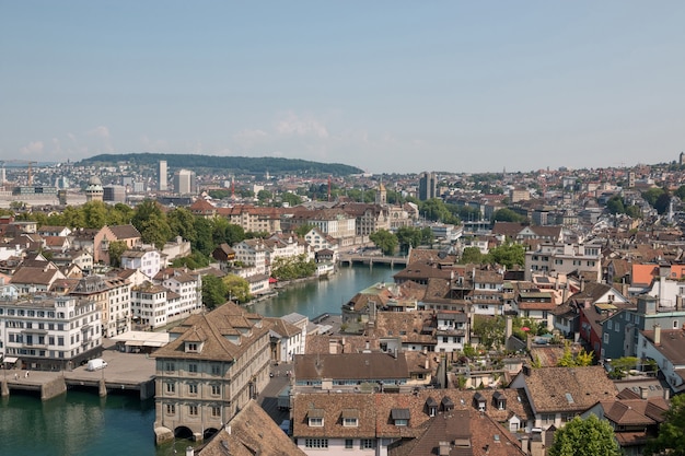 Вид с воздуха на исторический центр Цюриха с рекой Лиммат от церкви Гроссмюнстер, кантон Цюрих, Швейцария. Солнечный день летом