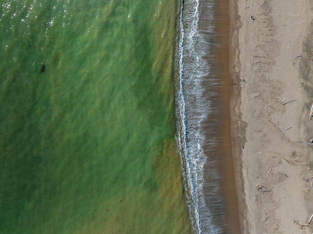 Aerial view of the huge pacific ocean waves hitting the shore