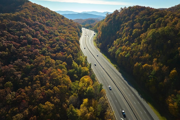 Aerial view of I40 freeway in North Carolina leading to Asheville through Appalachian mountains in golden fall with fast moving trucks and cars Interstate transportation concept