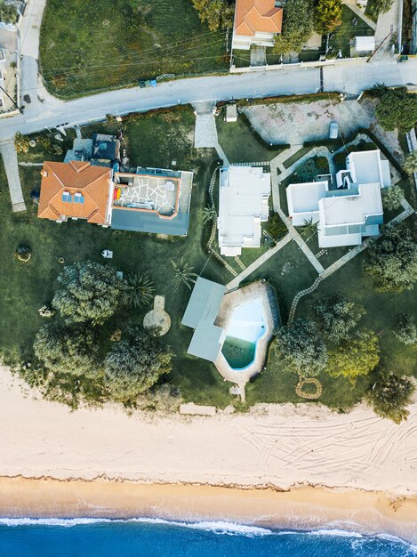 Aerial view of the idyllic sea shore on the sithonia peninsula in halkidiki high above the roofs of the resort village with villas bungalowwith swimming pools