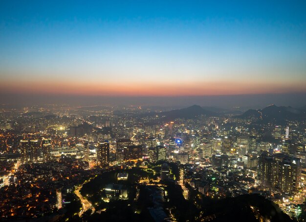 Aerial view of illuminated cityscape against sky during sunset