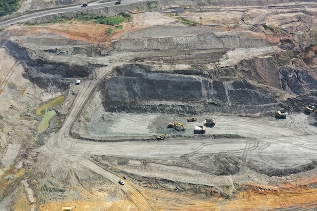 Aerial view industrial of opencast coal mining with lots of machinery at work - view from above.