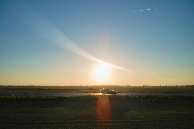 Aerial view of intercity road with blurred fast driving car at sunset Top view from drone of highway traffic in evening