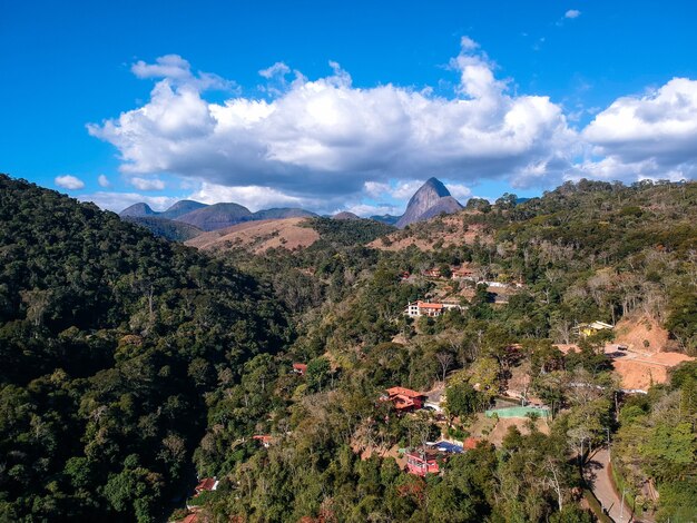 Itaipava, PetrÃƒâ³polis의 공중 전망. 브라질 리우데자네이루의 산악 지역인 PetrÃƒÂ³polis 주변에 푸른 하늘과 약간의 구름이 있는 산. 드론 사진. 맑은 날.