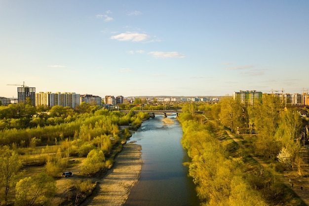 Bystrytsia川と遠くに建設中の高い住宅の建物があるウクライナのイバノフランコフスク市の航空写真。