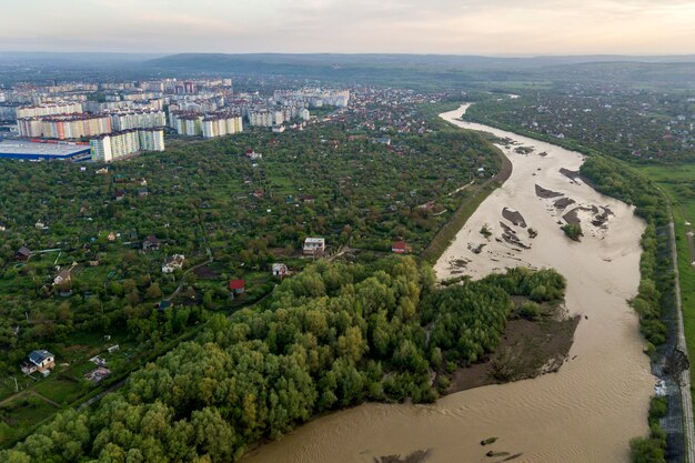 Aerial view of Ivano-Frankivsk city with residential area and suburb houses with a river in middle.