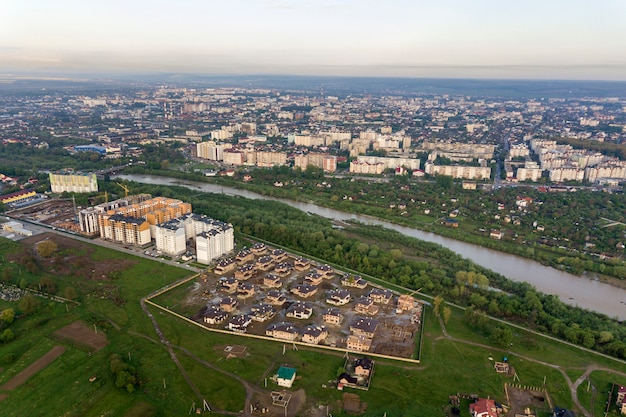 Aerial view of Ivano-Frankivsk city with residential area and suburb houses with a river in middle.