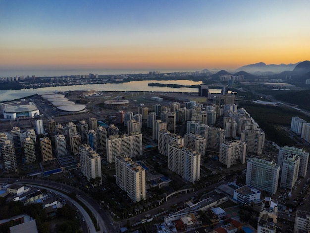 Aerial view of Jacarepagua lagoon in Rio de Janeiro Brazil Residential buildings and mountains around the lake Barra da Tijuca beach in the background Sunny day Sunset Drone photo