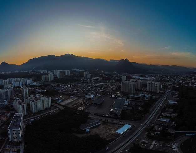 Aerial view of Jacarepagua in Rio de Janeiro Brazil Residential buildings and mountains in the background Sunny day Sunset Drone photo