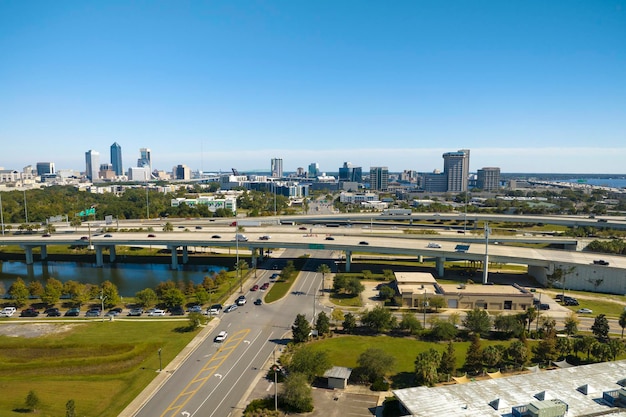 Photo aerial view of jacksonville city with high office buildings and american freeway intersection with fast moving cars and trucks usa transportation infrastructure concept