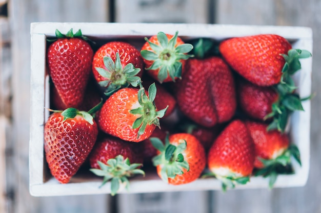 Aerial view of juicy strawberries in a wooden box