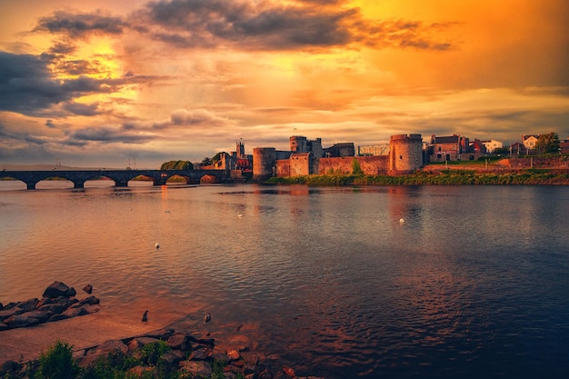 An aerial view of King Johns castle surrounded by water in Limerick during sunset