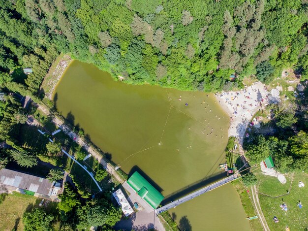 Aerial view of lake in forest with sand beach