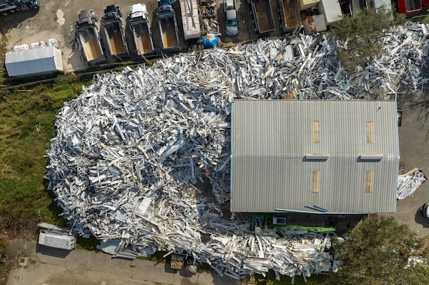 Aerial view of large pile of scrap aluminum metal from broken houses after hurricane Ian swept through Florida Recycle of broken parts of mobile homes