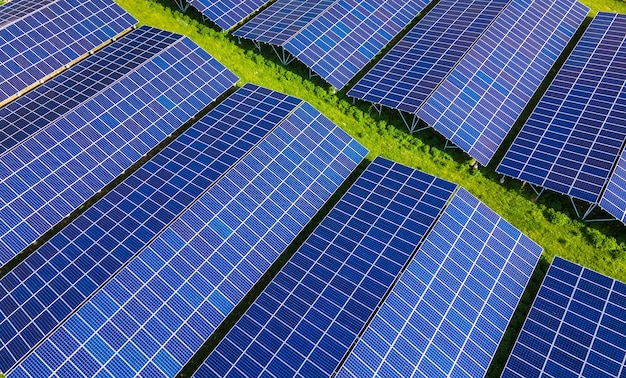 Aerial view of large sustainable electrical power plant with rows of solar photovoltaic panels for producing clean ecological electric energy. Renewable electricity with zero emission concept.