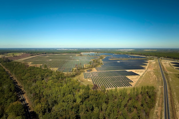 クリーンな電気エネルギーを生成するための太陽光発電パネルの列を備えた大規模で持続可能な発電所の航空写真ゼロエミッションの再生可能エネルギーの概念