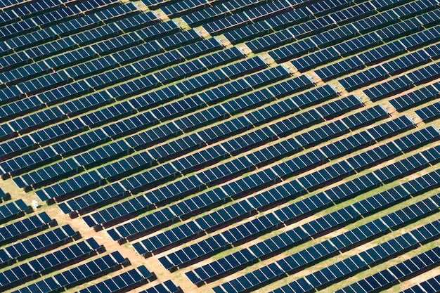 Aerial view of large sustainable electrical power plant with rows of solar photovoltaic panels for producing clean electric energy Concept of renewable electricity with zero emission