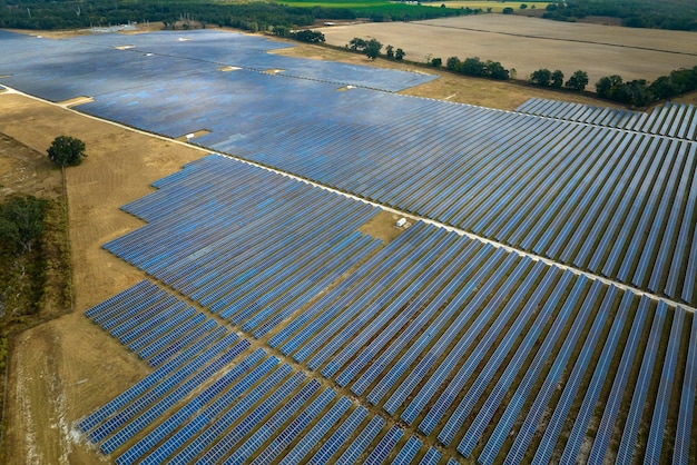 Aerial view of large sustainable electrical power plant with rows of solar photovoltaic panels for producing clean electric energy Concept of renewable electricity with zero emission