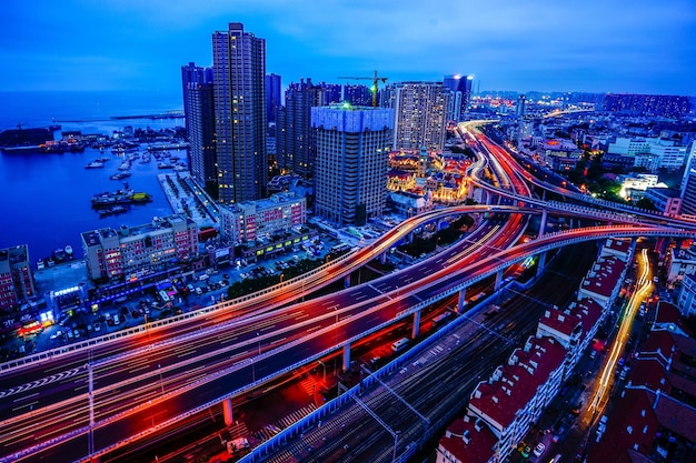 Aerial view of light trails on multiple lane highways in city at dusk