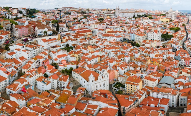 Aerial view of Lisbon Alfama district Plenty of traditional crowded antique residential houses with orange clay triangle roofs on the hill of Lisbon Portugal