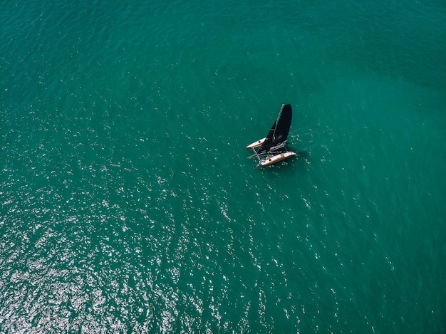 Aerial View Of   little yacht with black sail  At The Andaman sea. Phuket. Thailand