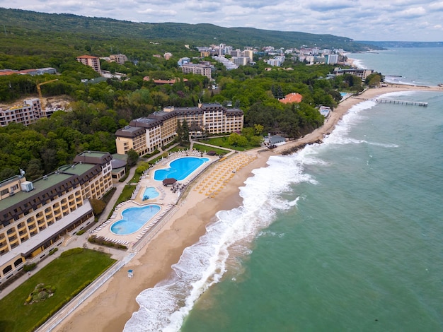 シーズンの初めにゲストを迎える準備ができている海辺のプールを備えた豪華なホテルの空撮