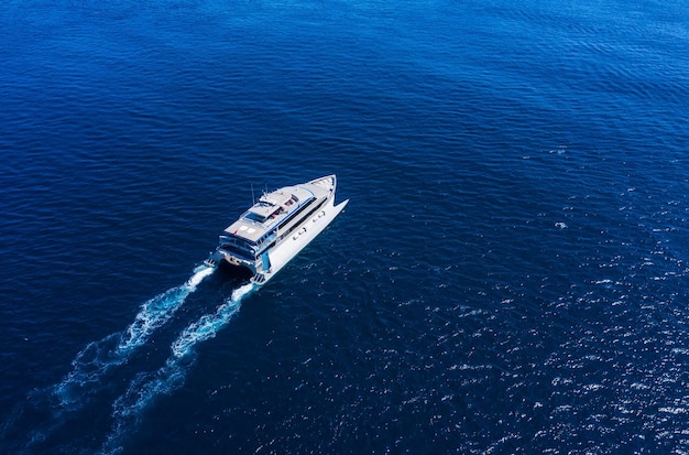 Aerial view of luxury floating cruise ship on transparent turquoise water at sunny day Summer seascape from air Top view from drone Seascape with cruise ship Travel image