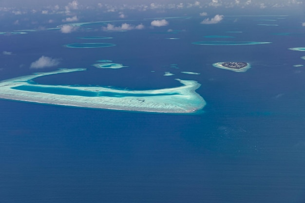 Aerial view of Maldives resort luxury travel destination Birds eye view deep blue sea coral reef