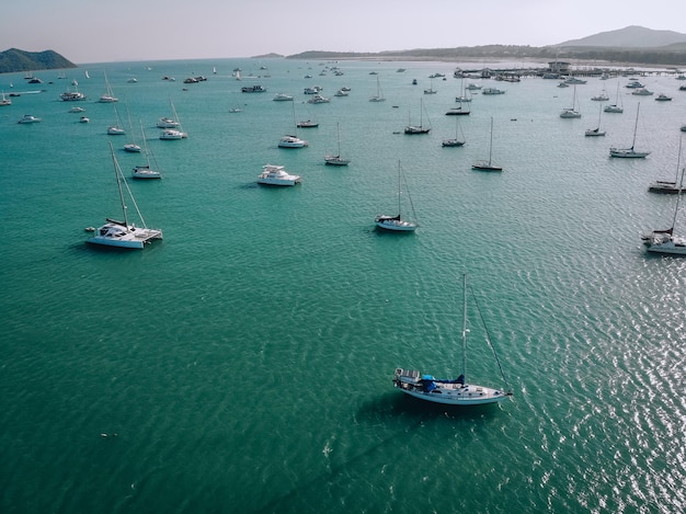 Aerial view of many anchoring yacht in open water. Ocean and sea travel and transportation. Phuket. Thailand