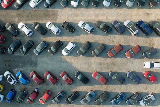 Aerial view of many colorful cars parked on dealer parking lot for sale