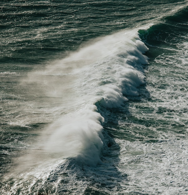 Vista aerea di un'enorme onda che si infrange nel mezzo dell'oceano