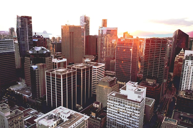 aerial view of modern buildings in city against sky during sunset