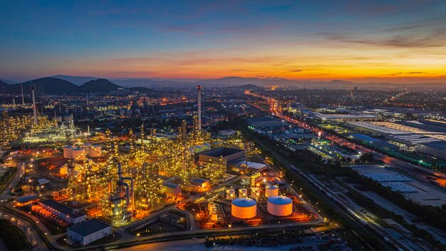 Aerial view of the morning of the oil refinery from the drone of the tower of the petrochemistry industry in the oil and gas industry with cloud sun orange