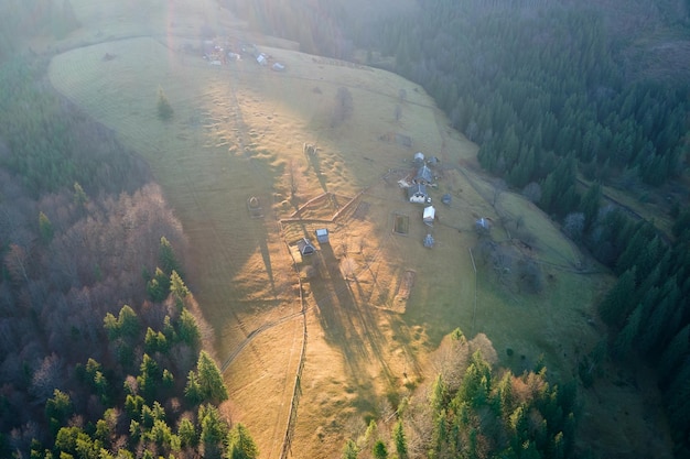 Aerial view of mountain hillside with small shepherd huts in evening