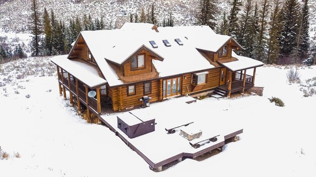 Aerial view of the mountain house covered in snow in the Winter.