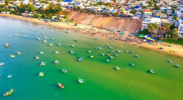 Foto vista aerea del villaggio di pescatori di mui ne al mattino con centinaia di barche ancorate per evitare le tempeste