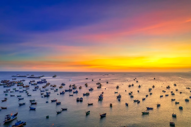 Aerial view of mui ne fishing village in sunset sky with hundreds of boats anchored to avoid storms